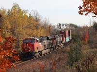 The sound of golf carts rattling the bridge over CN's Halton subdivision are momentarily drowned out by the rumble of a pair of GE built prime movers digging into the Halton Hills as they drag stack train 148 eastward towards Toronto. The fall colours are rapidly fading at mile 30 as the train comes to a brief stop just prior to the road crossing for what ever reason. Within a few minutes the train is once again on the move, and within a few minutes the sound of the golf carts crossing the bridge and the sound of golf clubs making contact on the course will once again be the dominant sounds.