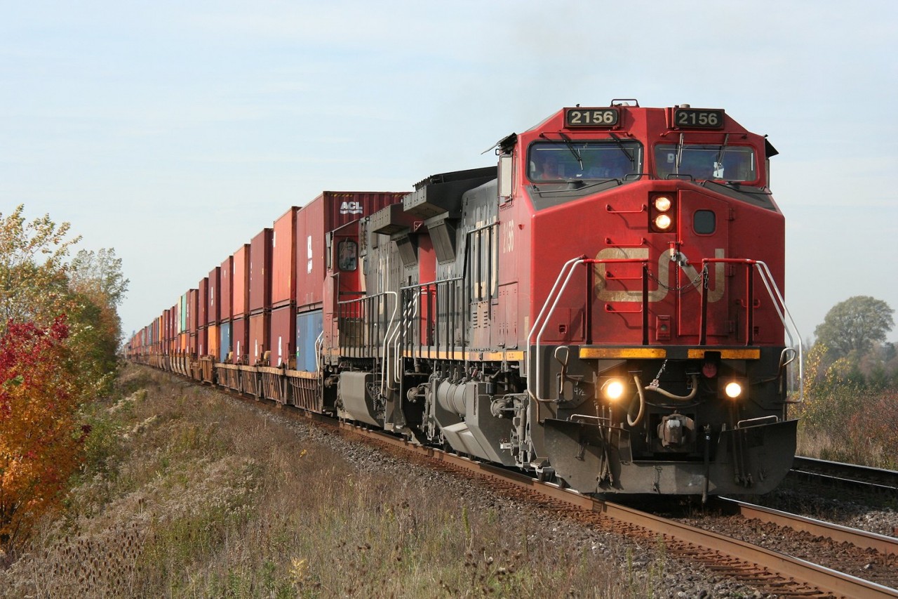 A pair of GEs lead late-running eastbound container train no. 148 on a fine fall day near Watford West.