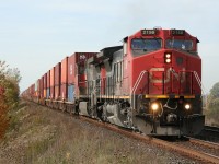 A pair of GEs lead late-running eastbound container train no. 148 on a fine fall day near Watford West.