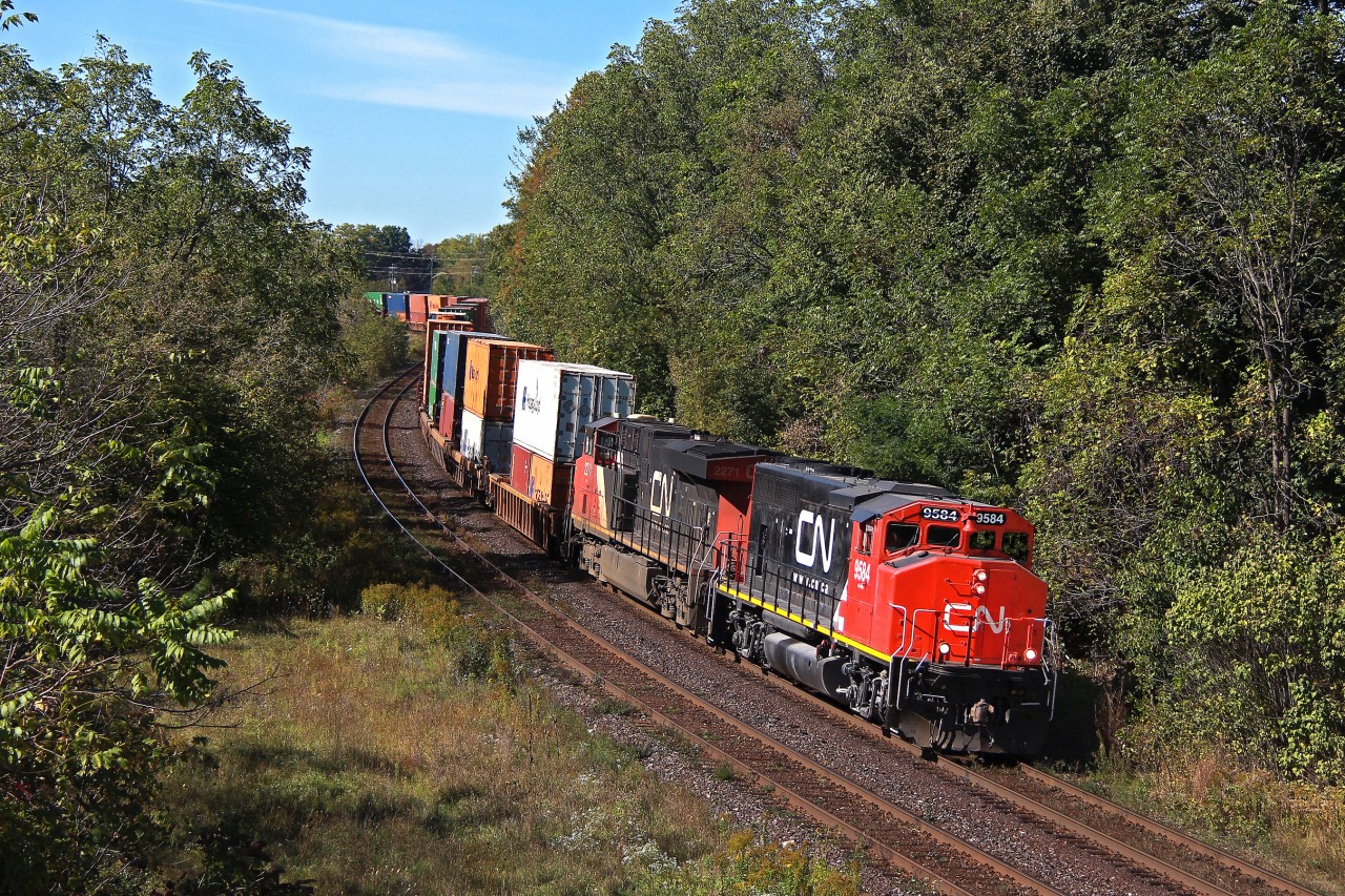 So this was CN's second oddball of the day in southwestern Ontario. Once standard power on CN Laser single stack trains, and even the early double stack trains, the GP40-2W's have for the most part fallen into obscurity or yard service. 148 and 149 are known for often having eye turning power though, at least for this part of Ontario. It's no secret that CN's Homewood yard hordes a number of older EMD units, particular of GP40 variety. Sure enough, a simple RR picture archives check indicates 9584 is a Homewood based runaway that had roamed the old IC and GM&O for almost 5 years. Perhaps short of power for a higher priority Q train, it finally got the call to return to Canada on a typically light loaded 148 where 8000+ horses just isn't required. Could it have come on a more fitting train really? Running a Q train just like they used to do best. Unfortunately the IC shoppers repainted 9584 in late 2013, though in the end, it's a GP40 that's not on a local. Rare I think would be an understatement. Being in the lead is an added plus.

Unfortunately the 645 prime mover wasn't screaming, though a loud healthy Canadian tuned three chime and brass bell clanging away for the Market Street crossing up ahead sure evoked some strong memories. Doing the honours of course is 9584, and 2271 thankfully trailing. CN MOW crows had just been working on the Paris trestle, and luckily cleared out of this shot a couple minutes before. It often takes a lot for me to get my lazy self off to the Dundas Sub, but needless to say, the show that CN put on this day was more than enough.