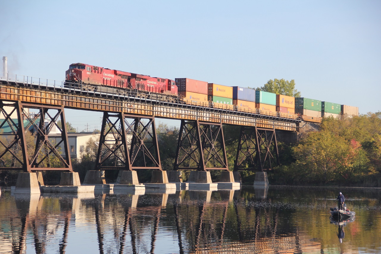A lone fishermen pays no attention to the CP west bound stack train starting across the Trent river in the early morning sun light. common power on a common train by today's standards. Track work on the north set of rails east of the bridge this summer, Does CP have excess to the Cascade paper plant to the north?