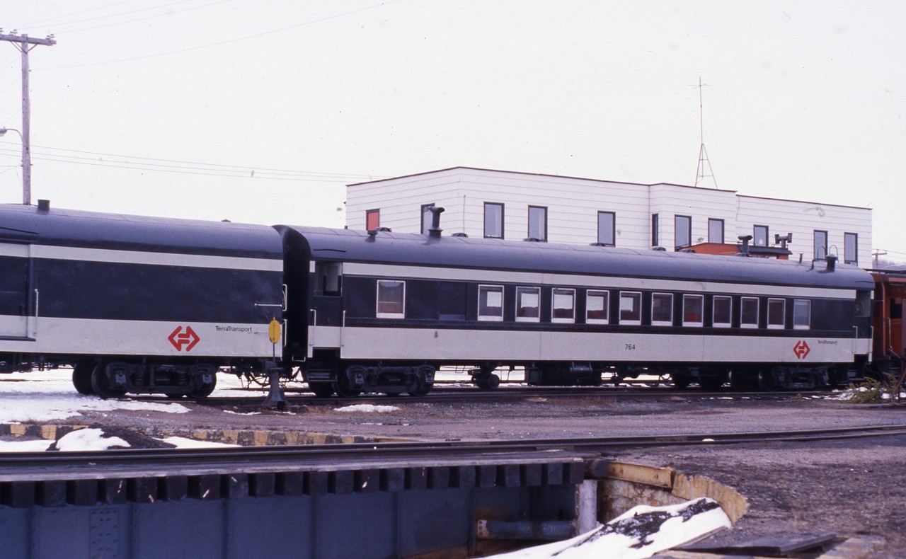 RECENTLY REFURBISHED. Terra Transport baggage car 1308 and coach 764 are captured just prior to the departure of Mixed Extra 935 West at Bishops Falls, Newfoundland on April 16, 1988. Having been taken out of service for the prior 3 months following a CTC ruling that saw the mixed cancelled for the winter months, it and the baggage car were restored to pristine condition by the TT Shops in St. John's. With an imminent but not yet confirmed closure, the turntable in the foreground was now in the locked position. Built in 1949 by the Canadian Car and Foundry as coach No. 47 for the Newfoundland Railway and later renumbered 764 under the CNR, it survived the shutdown of the narrow gauge system in September of that year and now makes a wonderful addition to the permanent display at the Lewisporte Train Park.