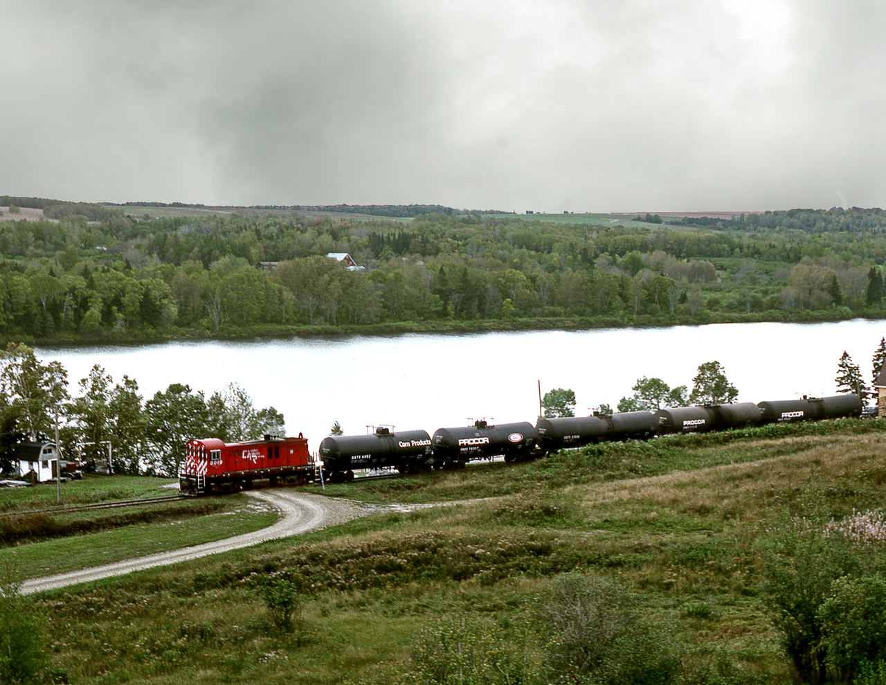 The last remaining segment of CPR's Maritime operations, the McCain spur from St.Leonard to McCain plant at Grand Falls NB, sees RS23 8019 heading east along the St.John River to the McCain plant. The line was sold to CN later that year and now abandoned