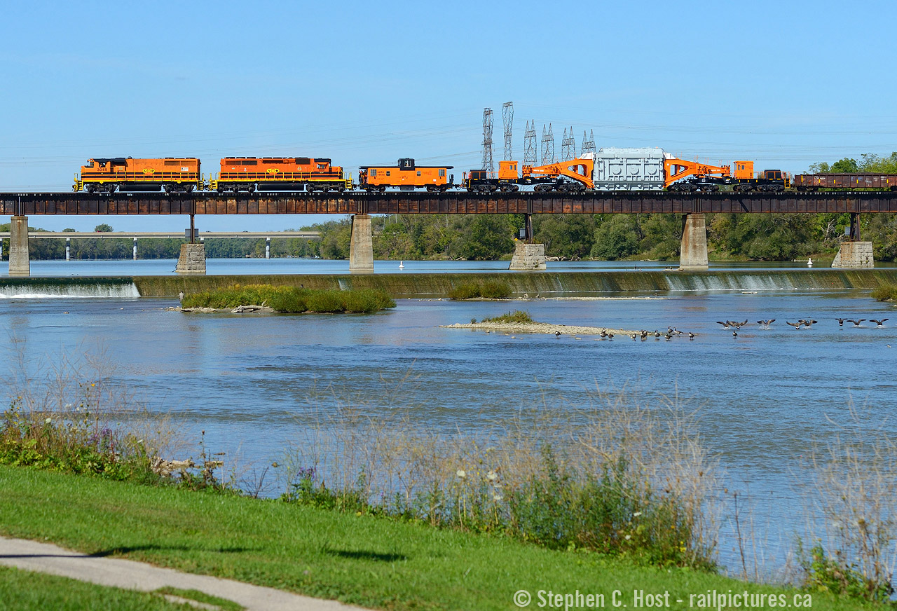 It would seem this train has quite the audience, as a flock of Canada Geese face the menacing orange beast, and a group of birds at the right are about to take flight. Fishermen are also in the water enjoying the beautiful day, and us rail-nuts were flocking to the banks of the Grand River snapping photos of this rather interesting and rare morning move. I chose this scene as I've seen it dozens of times in the last decade driving through Caledonia for Port Dover and I'd consider this a bucket list shot, a rather pretty location and a nearly perfectly matched train including the Schabel. You can count on one hand how often SOR runs through here in the morning in daylight on an annual basis, let alone a beautiful day like this. To me, you just can't beat this folks, this is my train heaven. 
To facilitate this move 597 ran light power to Brantford in the afternoon on September 30 (after CN dropped the car off in the morning) and parked for the night in Brantford yard. Hydro one crews must be available to move the car and they already had a busy morning, so after rest, Hydro One crews reported for duty at Brantford for 0800 on October 1, SOR crews arrived by taxi around 0900 and the train got underway around 1000, passing Caledonia just before noon. For more on HEPX 200 see  Tom Daspit's HEPX 200 page which I contributed to 15 years ago..  the site even has diagrams and other technical details.