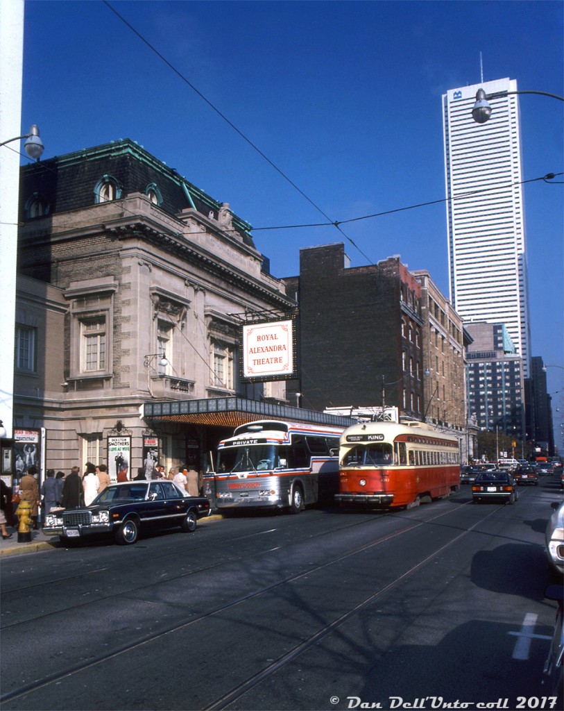 TTC PCC 4383, operating on the King route westbound to Dundas West Station, passes the Royal Alexandra Theatre and a private GMC "Buffalo" coach unloading theatre-going patrons outside on King near Simcoe. The beaux-arts theatre was constructed in the early 1900's, and since the 60's has been owned by Mirvish Productions (Ed Murvish of Honest Ed's fame), who also operated a chain of restaurants next to the "Royal Alex" along King Street. It is protected by both federal and provincial heritage designations. The clean white First Canadian Place office tower (4 years old at the time, its Carrara marble still looking fresh), as well as the old Lord Simcoe Hotel (demolished starting the next year) are visible in the background of the King Street strip. By now the old CP Express freight sheds and offices that would have been to the right out of frame have been leveled for (pre-Roy Thompson Hall) parking lots.

The TTC 4300 (class A-6), 4400 (A-7) and 4500 (A-8) series of PCC's were some of the last ones to hang on in regular service, being phased out in the late 80's and early 90's due to age, deterioration, and deliveries of new articulated ALRV streetcars. 4383 was still active in 1989, but retired and sold for scrap with a group of sister cars a year later. The King streetcar still operates today, one of the busier streetcar routes in the city along with Queen.

Photographer unknown, Kodachrome from the Dan Dell'Unto collection.