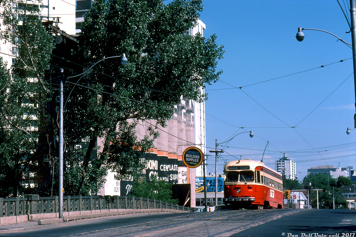 When Toronto was still debating whether to keep its streetcars or not in the 70's, a number of transit and rail photographers turned their cameras toward the Mount Pleasant streetcar line that faced an uncertain future, including Robert McMann. Seen here, TTC A-8 class PCC 4518 heads southbound on Mount Pleasant just below Merton, climbing the old CN Belt Line bridge and passing the landmark Dominion Coal and Wood silos, a month before streetcar abandonment on this route.

The Mount Pleasant streetcar service had begun in 1925 as part of the St. Clair streetcar route, until it became its own route in 1972 from St. Clair subway station to Eglinton Loop at Eglinton & Mount Pleasant (note the southbound car is incorrectly signed up for destination Eglinton, when it should read St. Clair). This aging bridge in the photo was the catalyst for discontinuance: it needed replacement, and that combined with track rehabilitation costs of the line opened up the can of worms to keep Mount Pleasant as a streetcar line or convert it to cheaper trolley or diesel buses. After changing decisions once or twice due to pressure from local residents, and the Metro Roads department, it was announced in July 1976 as a bit of a surprise that streetcar service was to be discontinued that month (all this after it had been announced in April the route would be kept and rehabilitation work made the next year). The last car to use the line was a Peter Witt charter early on the morning of July 25th 1976.

As for the CN Belt Line rail spur (originally built as the Toronto Beltline Railway in the 1890's, then used by Grand Trunk and later CN for serving local industries), the line extended east from the CN Newmarket Sub at Fairbank to serve a number of local customers along the way such as Fairbank Lumber, the TTC's Davisville Yard (new subway deliveries), and Dominion Coal & Wood, and ended just east of the bridge pictured (the siding for the silos here was a westward facing switch on the east side of the bridge). This eastern portion of the line through Forest Hill and to Mount Pleasant was likely doomed by low traffic and the new Spadina Expressway construction that would sever it around Mile 1.66 by Marlee Avenue. CN lifted the rails starting in April 1970 (it had apparently last seen service east of  Mile 1.66 in 1969), and the raised berm the line occupied across the Spadina Expressway "pit" was eventually removed by 1975 (visible here, although the Expressway would not be complete for a number of years). The city acquired the right-of-way in 1972 for park or trail use (eventually becoming the present day Kay Gardiner Beltline trail, including the western portion of the line that lasted until its own abandonment in 1988). The Dominion silos lasted until 2001 before being demolished for condos.

TTC 4518 was a little luckier: rebuilt as A-15 class car 4615 for Harbourfront line service in 1985, it currently resides at the Kenosha Streetcar Society in Wisconsin, with 5 other ex-TTC cars.

Robert D. McMann photo, Kodachrome from the Dan Dell'Unto collection.

References for further reading:

Branchline magazine, July-August 2001 (25th Anniversary, TTC Mount Pleasant Carline Abandonment).

Transit Toronto - The Mount Pleasant Streetcar (deceased).