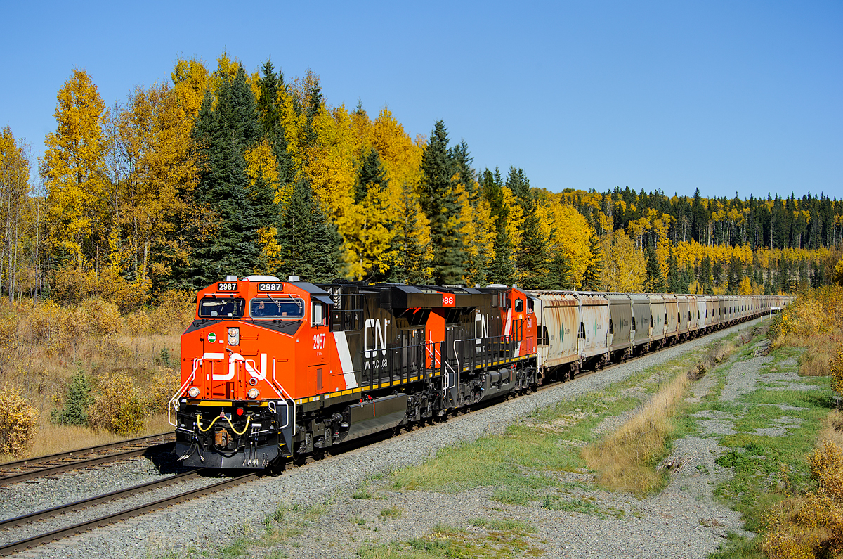With the fall colours a blaze, brand new CN ES44ACs 2987 and 2988 are making their maiden run west, climbing through Medicine Lodge with loaded potash train B759.