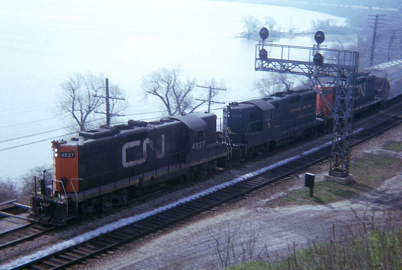 Here is one of those tough shots, but had to take it.  It was rare when I saw something like a C&O Geep in consist of a CN train back then.  This image of CN 4527, C&O 6153, CN 45xx rounding the bay out of Hamilton was made more difficult a capture due to the fact I am shooting against the sun and having contend with heavy mist/fog rising off the harbour, making detail offshore impossible. Interesting, I guess, just for the foreign GP. I think this is the only time I caught one in a CN train.