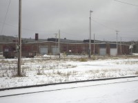 On a cold and crisp December 18, 2001 I was in Hornepayne, ON putting a new snow clearing machine into service for CN. After going through basic training with the operator and mechanics I wandered around the yard to snap a few photos. While the weather was not cooperating with adequate lighting or warmth, I made the best of my time capturing what I could because it was quite evident that with each passing year there would be less and less to shoot in the once thriving division point. The two roll up doors on the end of the house provide access to the Work Equipment repair area where MOW machines are serviced, repaired, and often stored during the winter. The two silver roll up doors seen in the middle of the photo provide access to the under roof turntable within this unique structure.
A great view of the turntable can be had by viewing Craig Allen's photo from 01/01/2000 http://www.railpictures.ca/?attachment_id=13460
From where I was standing to take this shot of the roundhouse, I turned 180 degrees to capture this view of the deteriorating Hornepayne station http://www.railpictures.ca/?attachment_id=20428
I'm guessing that 16 years later in 2017 the entire area looks even more depressing.
