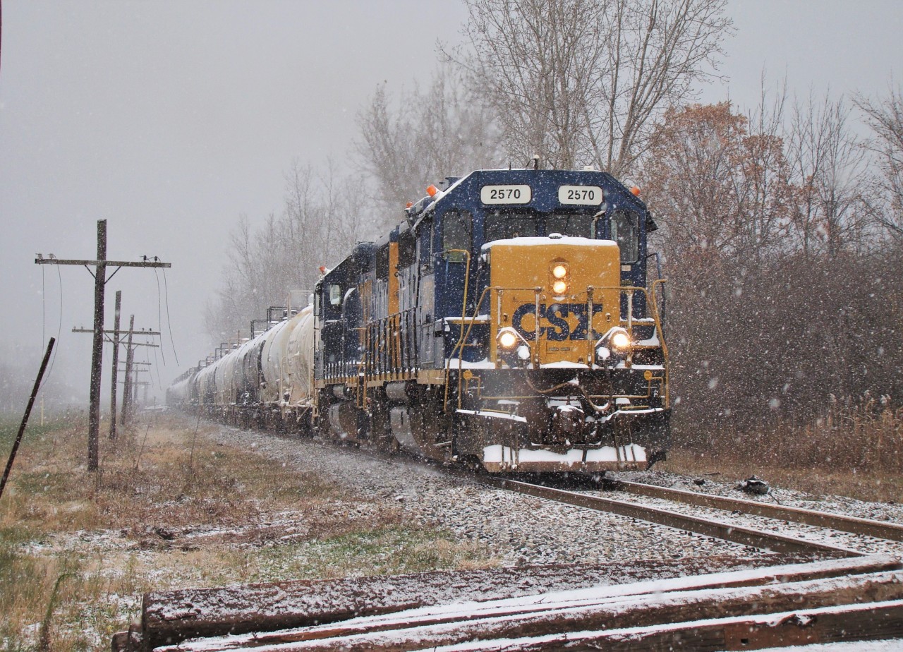 With the flurries flying, CSX 2570 & CSX 2757 head their 39 car train past Lasalle Rd. after interchanging with CN. They departed the station in the sun around 10:00, switched the yard then brought a single tank car down to Praxair before shoving three back to the yard. They then picked up their train of 59 tank cars and headed over to CN, returning here at 15:20.