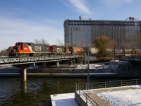 Most of CN's GP38-2's and GP38-2W's are very ratty-looking, but GP38-2 class leader CN 4700 is looking quite good as it temporarily advances over the Lachine Canal (with CN 7228 trailing), before shoving back towards Bickerdike Pier with a cut of grain cars.