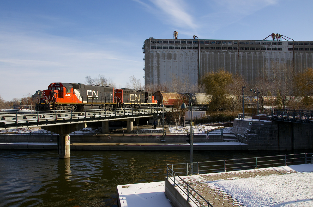 Most of CN's GP38-2's and GP38-2W's are very ratty-looking, but GP38-2 class leader CN 4700 is looking quite good as it temporarily advances over the Lachine Canal (with CN 7228 trailing), before shoving back towards Bickerdike Pier with a cut of grain cars.