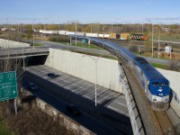 Amtrak's <i>Adirondack</i> is leaving CN's St-Hyacinthe Sub and taking the the Rouses Point Sub as it crosses over Route 116. In the background is Southwark Yard, including CN 9576, which is switching CN 522.