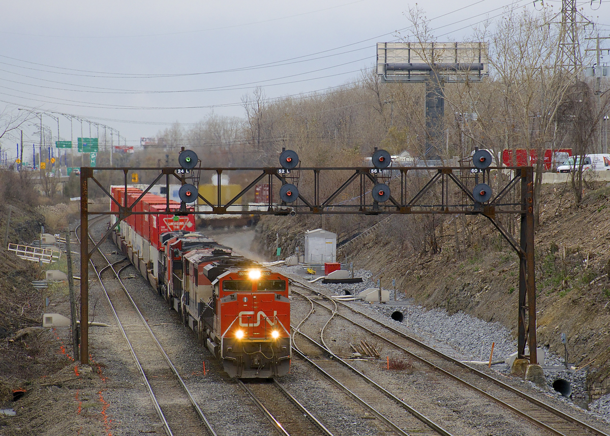 A very long CN 120 (704 axles) is exiting Taschereau Yard with CN 8010, BCOL 4612, CN 2146 & CN 2267 for power up front and no DPU (a rarity recently). It is passing ditching projects on either side of CN Montreal's Sub; this area is prone to water accumulation during the winter or spring.