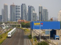 Cab car GOT 326 leads a westbound past GO Transit's Willowbrook maintenance facility at left (where a train is seen entering the yard) and VIA Rail's Toronto Maintenance Centre at right.