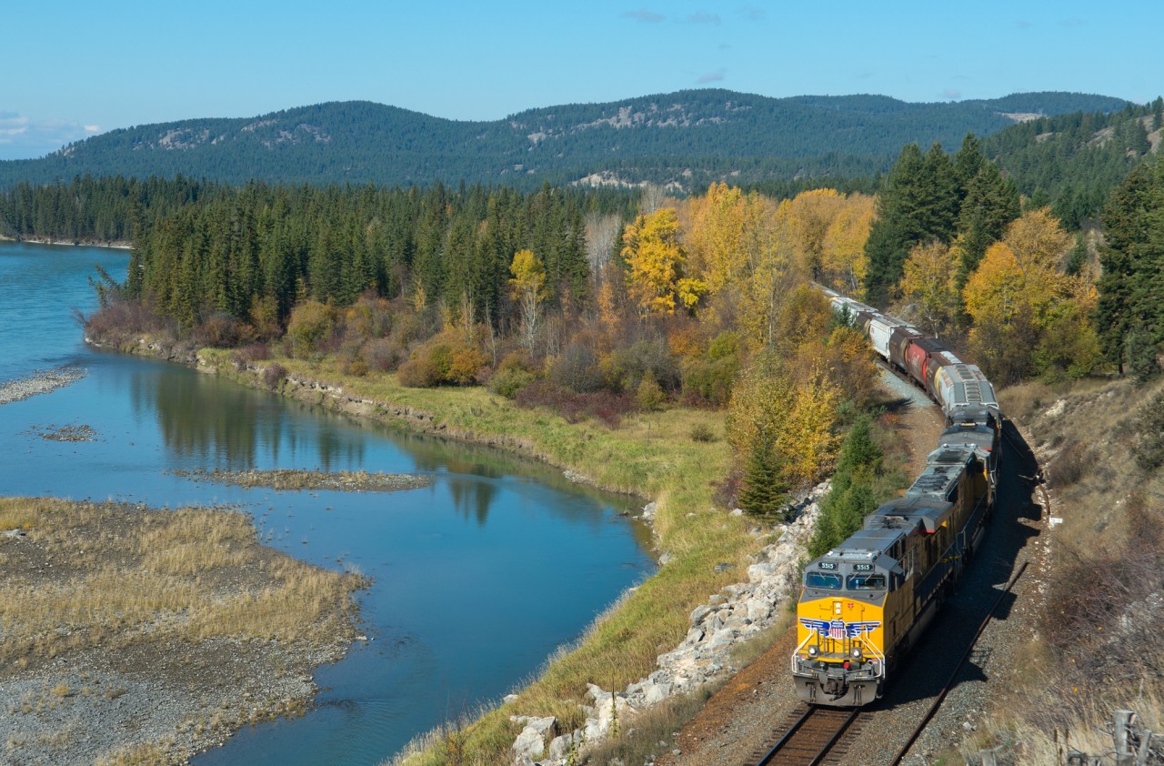 Shiny clean UP 5515 is in charge of an eastbound CP grain drag along side the Kootenay River in Fenwick BC.