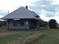 Elmira station, at the east end of the railway in PEI back in the day, was located near the end of the Elmira Spur off the Souris Subdivision.  The station was preserved and in 1975 a couple of passenger cars were rolled in for future artifacts. However, due to neglect, NOT the fault of the museum personnel themselves; a wooden baggage car was lost to arson, and the car in this image, a steel sided Canadian National RPO car #9722, succumbed to deterioration from the salty climate over the years and was scrapped. All that is left of the two cars at the museum is a truck. To this day, the station, however, has been kept in great condition and the museum has flourished in recent years and is well worth a visit. There is a new building housing a riding model railway, a CN wood caboose #78431, ,  hand car and track into the woods has been kept; and this year one of those small community wait stations (CN Porthill) has been brought in, and is situated down the line along the approximate half mile of track that has been preserved.
As mentioned in a previous caption, PEI's railway (PEIR) was built 1880s, last train Dec 31, 1989; track taken up by 1992 and the RoW bought by the provincial government in 1994 in order to form the Confederation Trail, and it is a beautiful piece of work.
Elmira Station is registered in the list of Historic Places.