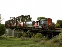 [Editors note: rare] CN's Emerson wayfreight out of Winnipeg crosses the Red River at Emerson after turning on the wye on west side of river,Former NP junction. It will pick up cars off the BNSF(Former GN) including haulage cars for BNSF's yard at Winnipeg. The train operated in 2003 as a daily daylight turn