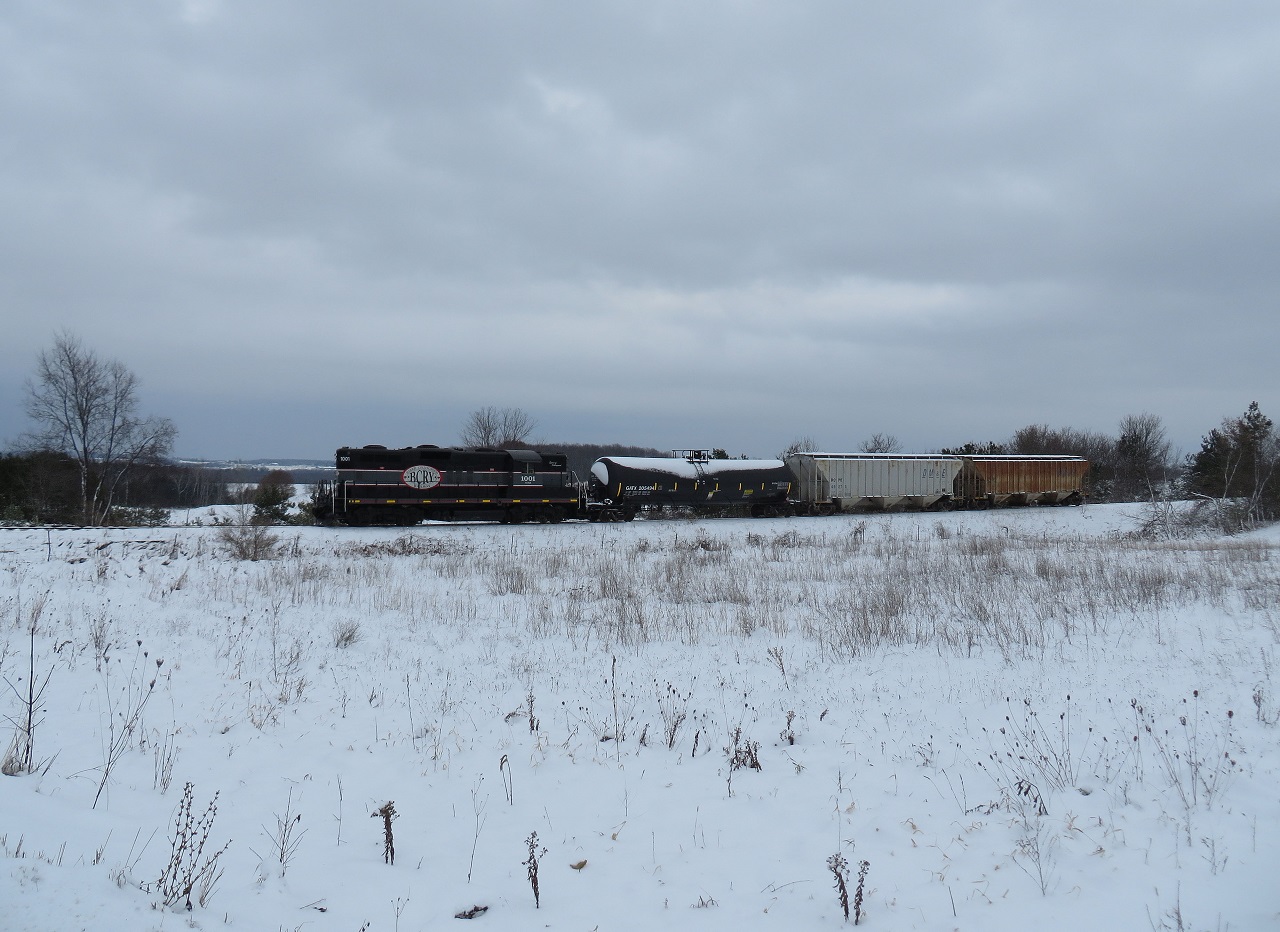 Shades of black and grey. On a grey day, 1001 returns from Innisfil with an empty tank car from Comet Chemical and a couple of loads for Tag Environmental.