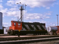 DIESEL DEPARTURE. NF210 # 945 is refuelled just prior to departure as the only unit on Terra Transport's Mixed Extra 945 West on April 20, 1987. This was the photographer and his girlfriend's (now wife) first ever trip on a Newfoundland train and the two would be the only passengers to travel the entire 138 miles in Coach 757 from Bishops Falls to Corner Brook that day. Narrow gauge unit # 945 was the second last in an order of 9 such 1200 horsepower units built by GMD to be delivered to the CNR's Newfoundland Division in 1960. Due to the excellent maintenance carried out by the shop crews after 28 years of service, it would be later sold to the F.C.A.B in Chile in 1988. 