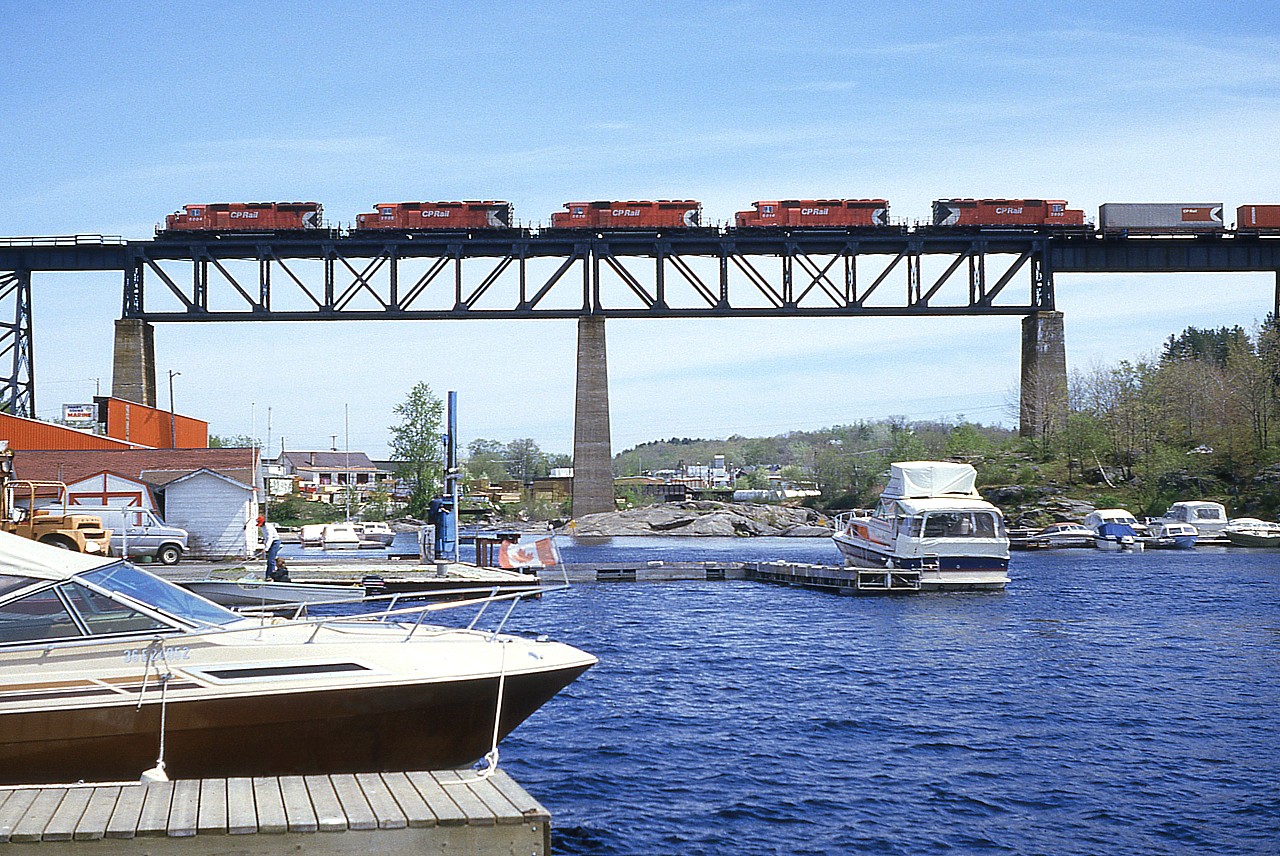 Well with today's powerful AC4400CWs and ES44ACs handling most of the tonnage to and from the west, one would be very hard pressed to see a set of locomotives like this any more. Even 30 years ago when I shot this, it was a real treat.  Here was have 5 SD40-2s running northward over the Sequin River at Parry Sound: CP 6004, 5905, 5670, 6014 and 5909. Note the local feller down on the dock. He isn't the least bit interested.