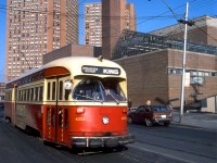 After departing Dundas West Subway Station and crossing Bloor Street, TTC PCC 4356 operates on an eastbound King run heading south on Dundas Street, passing Bishop Marrocco Secondary School and The Crossways Mall towers. Both still serve as landmarks at the busy Dundas-Bloor intersection today, which got even busier with the opening of the Union-Pearson Express (that stops a stones' throw away at Bloor GO/UPX Station). 
<br><br>
Note the water bumpers outfitted to 4356. The TTC outfitted various buses and streetcars with them starting in 1969, basically rubber sacks filled with a liquid saline solution that would pop out of plugs at the top during a collision and help absorb the impact (they were apparently phased out after it was found they were causing corrosion to the carbodies). Our intrepid and unknown photographer is visible at the bottom, no doubt bundled up well on this December afternoon. And yes, that appears to be an early Honda Civic parked out front (a brown 70's hatchback version). You probably won't find too many of those around these parts today, as those early Japanese cars were known to eventually rust to pieces after facing the usual Canadian winters.
<br><br>
<i>Original photographer unknown, Kodachrome from the Dan Dell'Unto coll.</i>