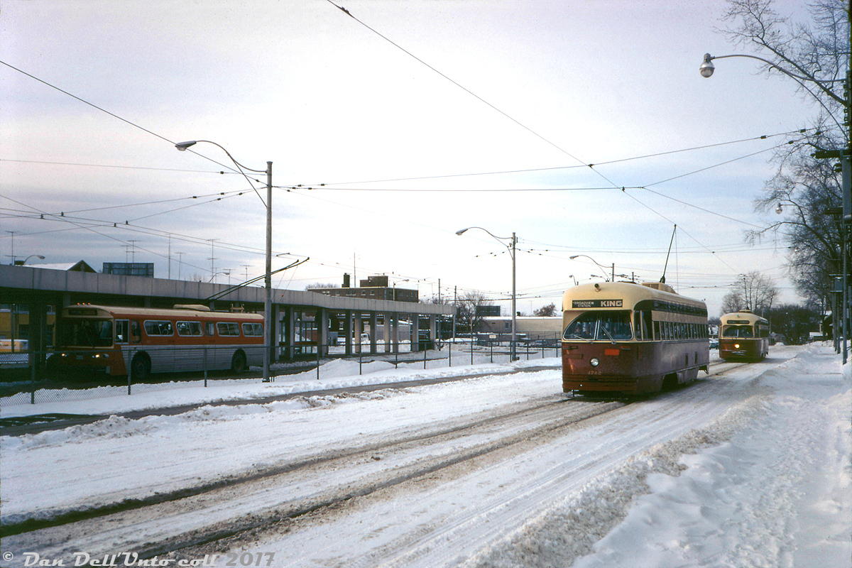 Lazily plowed streets and crunchy snow underfoot, a nippy December afternoon at Dundas West Subway Station finds TTC PCC 4742 (one of 48 "A-13" class cars acquired secondhand from Birmingham, Alabama in 1952) operating on the King route heading back east across town to Broadview subway station, having just departed the station onto Edna Ave. Following behind is a 43/4400-series PCC operating a Dundas car to City Hall loop. Still at the station, a relatively newer Flyer E700 trolleybus on the 40 Junction route waits to depart for Runnymede Loop south of the CPR yards in The Junction. The vehicles have changed and the trolleybuses have been replaced by diesel buses, but much of this scene remains the same 45 years later.Original photographer unknown, Kodachrome from the Dan Dell'Unto collection (with restoration/colour touch-up work).