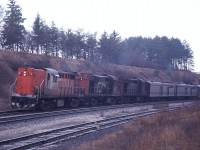 It certainly looks like a cruddy day, but the sun is actually out. Not that strong, it is a rather murky haze and the train is unfortunately backlit. Too bad, as it is an interesting combination on the head end of this eastbound passenger train, CN 3153, 3123 and 3113. The leader used for Tempo trains, the other two units mostly saw passenger service as well, either leaders on regular trains or helpers on such behemoths as the long weekend trains such as #75, etc. You never knew what to expect.