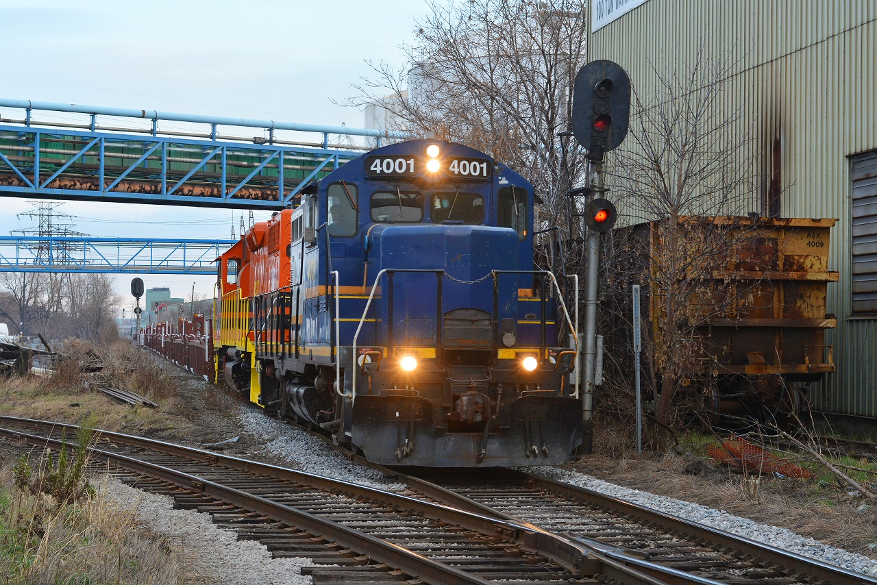 SOR crosses the diamonds of industrial Hamilton on the old N&NW with a head end cut of BNSF well cars and BRNX 2 bay hoppers from National Steel Car