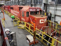 Ex Agincourt hump unit 6623 is having some air brake leaks under the engineer's side patched up to make it safe to travel on it's final voyage. Note the dual rear headlight conversion on the 5824 behind it.