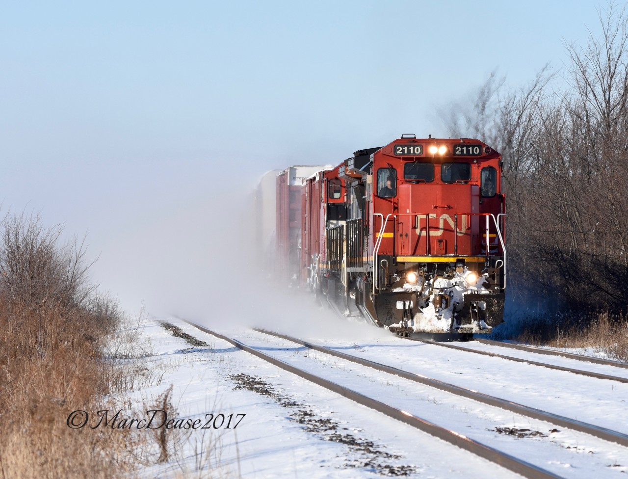 Train 394 with CN 2110 and CN 2162 stirs up last nights snow fall on its way out of Sarnia.