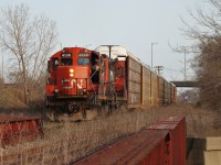 I was riding my bike down Dougall Ave. when I saw this Local creeping under the E.C. Row Expwy, so I parked it and walked up the embankment to catch these two GP 9's returning to Van de Water Yard with eight loaded racks from Gen Auto, which closed a couple of years after this photo. The yard where Gen Auto was once located is now used to load Chrysler products onto autoracks, much busier with what seems to be an average of 25 cars per day. Note in the lower right you can see a stamp for 1930, when the bridge was built by the Michigan Central RR. In the right evening light you can see the letters 'M.C.R.R.' bleeding through the faded paint on the bridge.