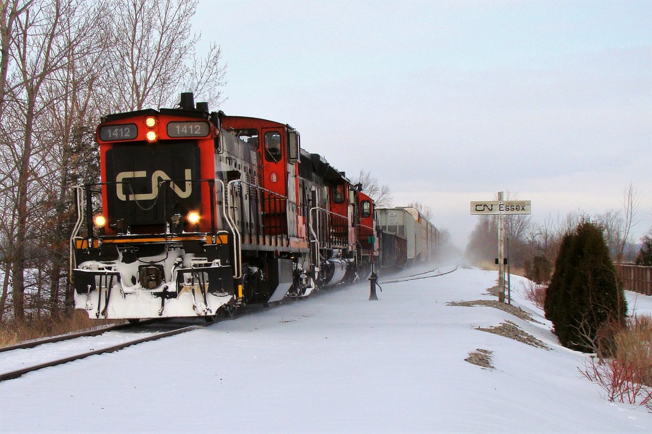 CN 438 lead by CN GMD1 1412, CN 6020 and CN 7058 lead a short freight just North of Essex over the CASO. The three locomotives and blowing snow give the impression of a much larger train, but back then as today, trains 438/439 didn't usually run on Sundays, so seeing this 9-car freight this day with this power was rather exciting. Caught it on my way to the Essex train show, only 78 days before total abandonment.