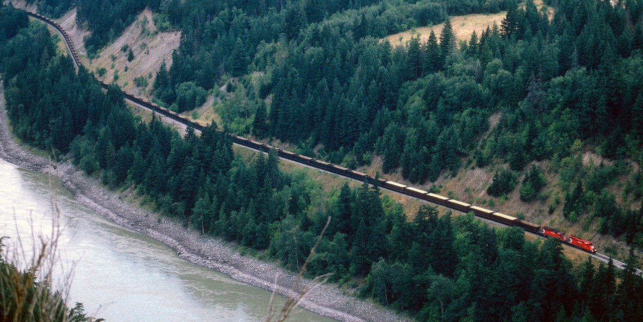 A Pair of SD40-2 from CP were pulling a long freight Train  - Open Hoppers , few were loaded with sulfide (yellow color) -  through Frazer River Canyon in 1991