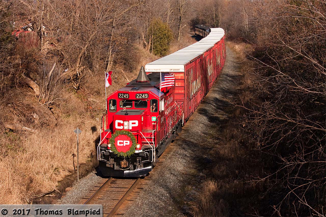 It's nowhere near as spectacular during the day, but here it is: the "ho ho train" (as the RTC called it). Having met 112 at Lovekin, the Holiday Train was running a little late as it approached its stop in Bowmanville. To say it was mid-afternoon on a weekday, the crowd was well over 100 people. I've forgotten how many times I've shot this train in Bowmanville and I really am running out of angles. The first time was back in 2007: it was a miserable night, the ground was covered in ice and freezing rain was falling. By the time I had my photos (they were really bad, I've learned a lot in the last decade), my hat was frozen solid with a layer of ice on it! For the past few years, CP have tightened the schedule and Bowmanville is now a daytime stop. The weather this year was very different compared with 2007. No snow, no rain, and double-digit temperatures. It doesn't make for dramatic photographs, but it sure is nicer weather to stand around waiting in.