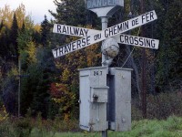 A rather unusual set of crossing signals, with bilingual crossbucks and top illuminating "Danger" sign, at one of the grade crossings along Canadian Pacific's line to Maniwaki in 1982.