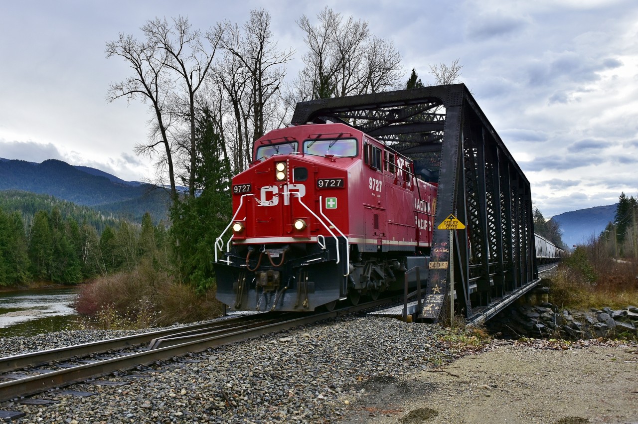 CP 9727 is crossing the Eagle River at mile 40.2 of the Shuswap sub and is in charge of an eastbound load of grain empties.