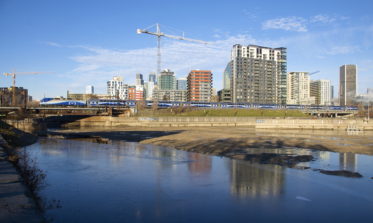AMT 1364 leads a deadhead move towards the maintenance centre in Pointe St-Charles as it passes the mostly empty Peel Basin.