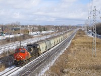 CN 3037 brings up the rear of potash train CN B730 as it kicks up the snow by MP 14 of the Kingston Sub during a brief period of sunshine. This 204-car train has CN 2949 and CN 3091 up front and CN 2937 139 cars from the front and is destined for Saint John, NB