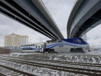 <b>Finally completed.</b> AMT 1329 is pushing AMT 61 towards its next stop at Dorval as it kicks up the snow. The train is passing under a set of overpasses that link Autoroute 20 with the Montreal-Trudeau airport and that were delayed for a number of years due to the government of Quebec failing to get permission from CN and CP to cross their right of ways here. 
