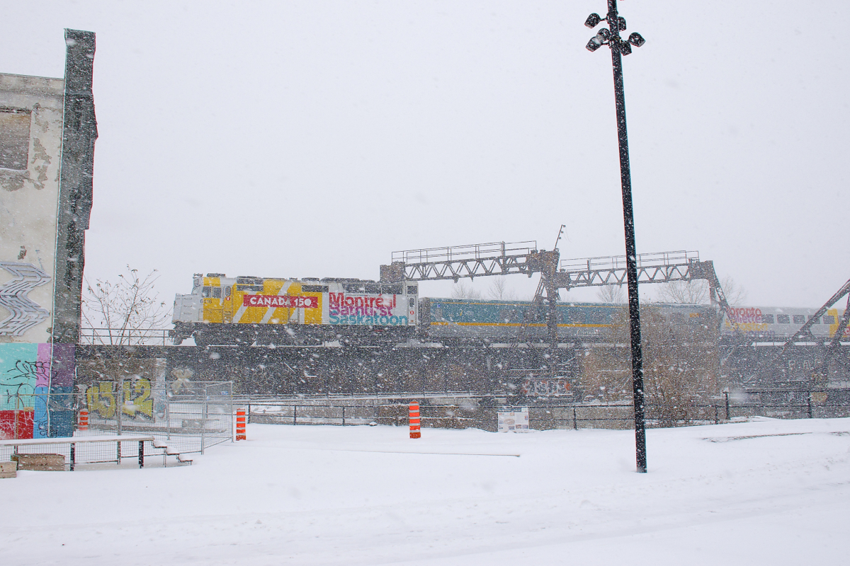Canada 150-wrapped unit VIA 6416 is leading a late VIA 60 towards Wellington Tower during a big snowstorm in Montreal.