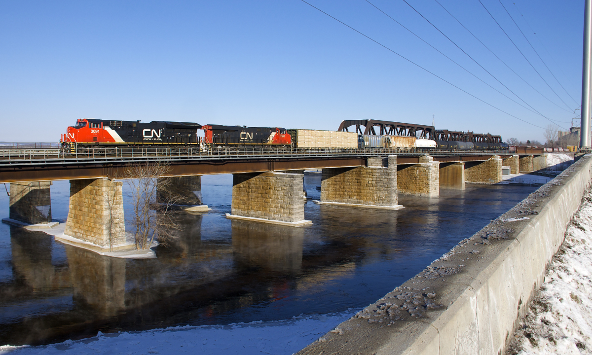 CN 3091 & CN 2952 lead CN 369 off the island of Montreal and over the Ottawa River on a cold but clear morning.