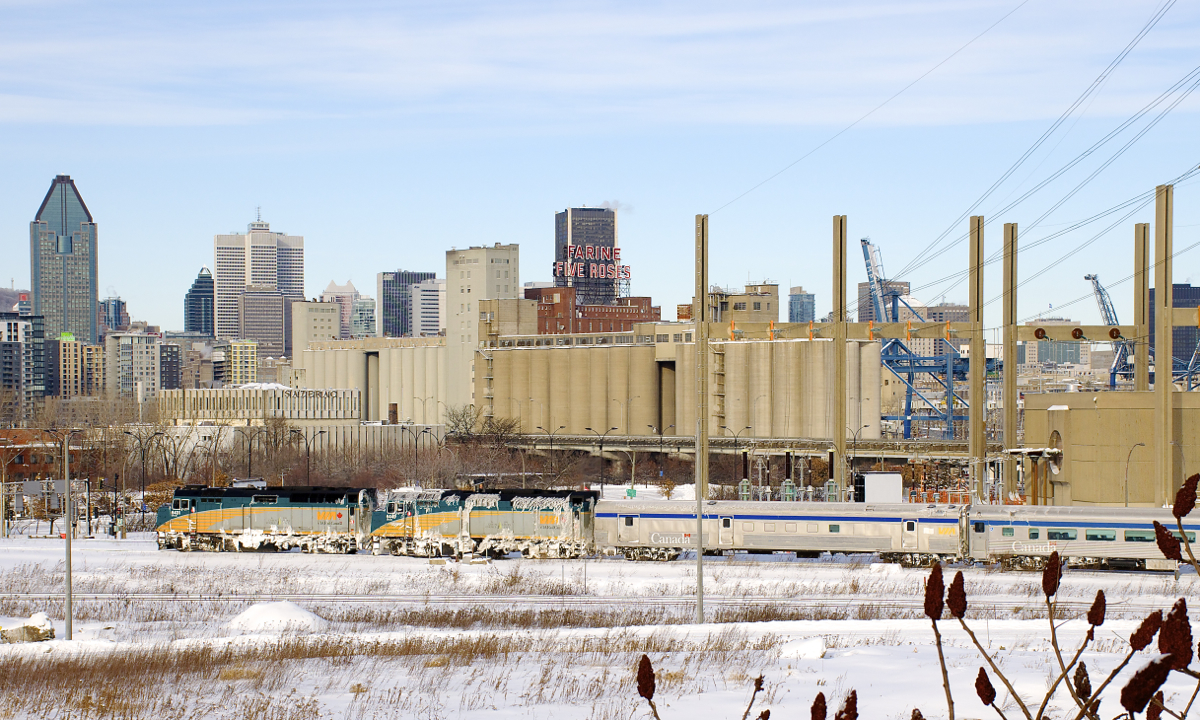 An extra edition of VIA Rail's Ocean (with an all-stainless steel consist) is passing Montreal's skyline with snow-covered VIA 6431 & VIA 6449 for power.