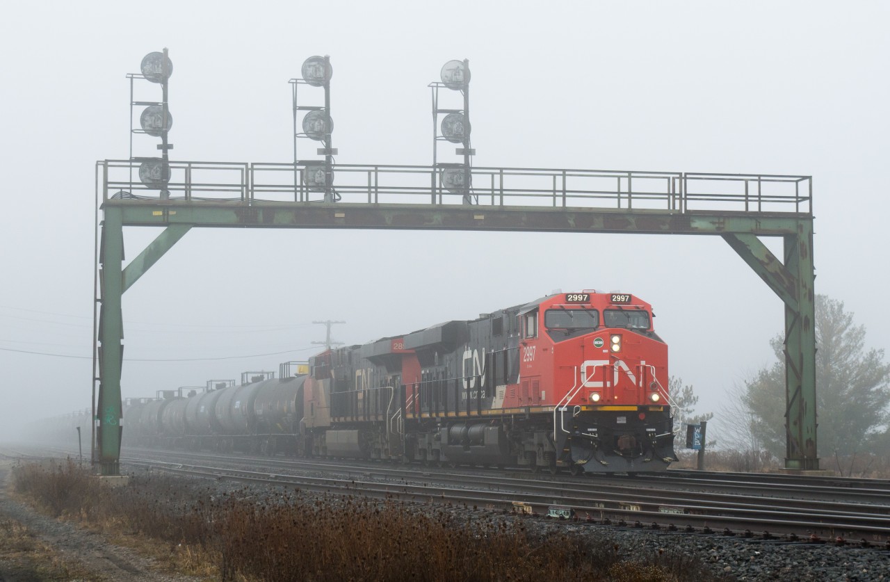 Brand new ES44AC, CN 2997 is seen shoving under the signal bridge at Paris Junction as M394 returns to its train after completing a lift from the North Service Track.  Thick fog blanketed most of Southern Ontario yesterday morning, making for a neat scene.