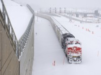 Arriving in Montreal around sunset on Christmas Eve, loaded potash train CN B730 was sent to park on what will be CN's new Montreal Sub right-of-way by the end of 2018. Here on Christmas day it is parked with rear DPU CN 3048 covered in snow after a large snowfall overnight.