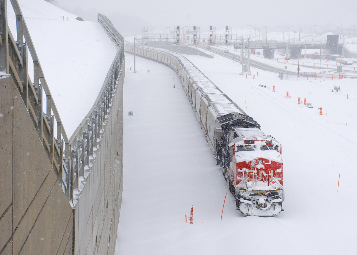 Arriving in Montreal around sunset on Christmas Eve, loaded potash train CN B730 was sent to park on what will be CN's new Montreal Sub right-of-way by the end of 2018. Here on Christmas day it is parked with rear DPU CN 3048 covered in snow after a large snowfall overnight.