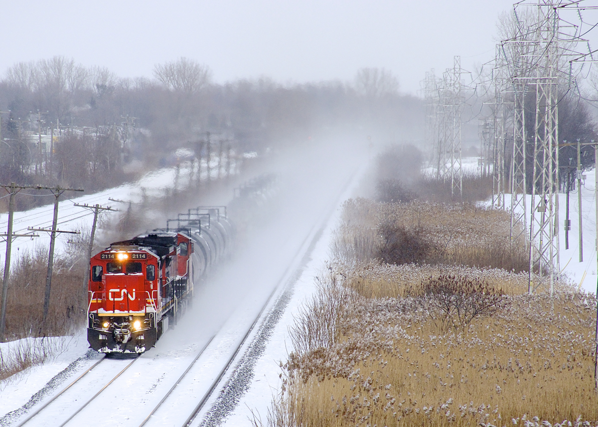 Most of CN 377's train is rendered invisible by the snow it's kicking up as it heads west through Pointe-Claire with CN 2114 & CN 2512 for power.