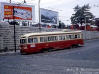 TTC A1-class air-electric PCC 4060 curves east from northbound on Dufferin Street to eastbound on Queen Street West, working a Kingston Road car to Woodbine Loop in the Parkdale area of Toronto on August 22nd 1964. The sign behind the streetcar says "CPR Parkdale Station", above an arch cut into the stone retaining wall and stairway that lead up to CP's Parkdale Station, the top of which is visible (closed a few years later in 1968 and later demolished). The red trucks lining the top of the retaining wall are for Canadian Pacific Express, who had their building next to the station.
<br><br>
Advertisements on the streetcar include ads for the 1964 Canadian Drum & Bugle Corps Championships, a horse show, and a partially obscured one for a Mickey Mouse performance at the Hummingbird Centre (only 50 cents!), plus billboard advertisements for Wonderbread white bread (some things never change), and Alpine Cigarettes.
<br><br>
<i>John F. Bromley photo, Dan Dell'Unto collection.<i/>