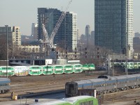 GO Transit CEM cab car in foreground with VIA passenger cars older GO Bi-level coaches and in background at the Willowbrook Yard in Mimico.