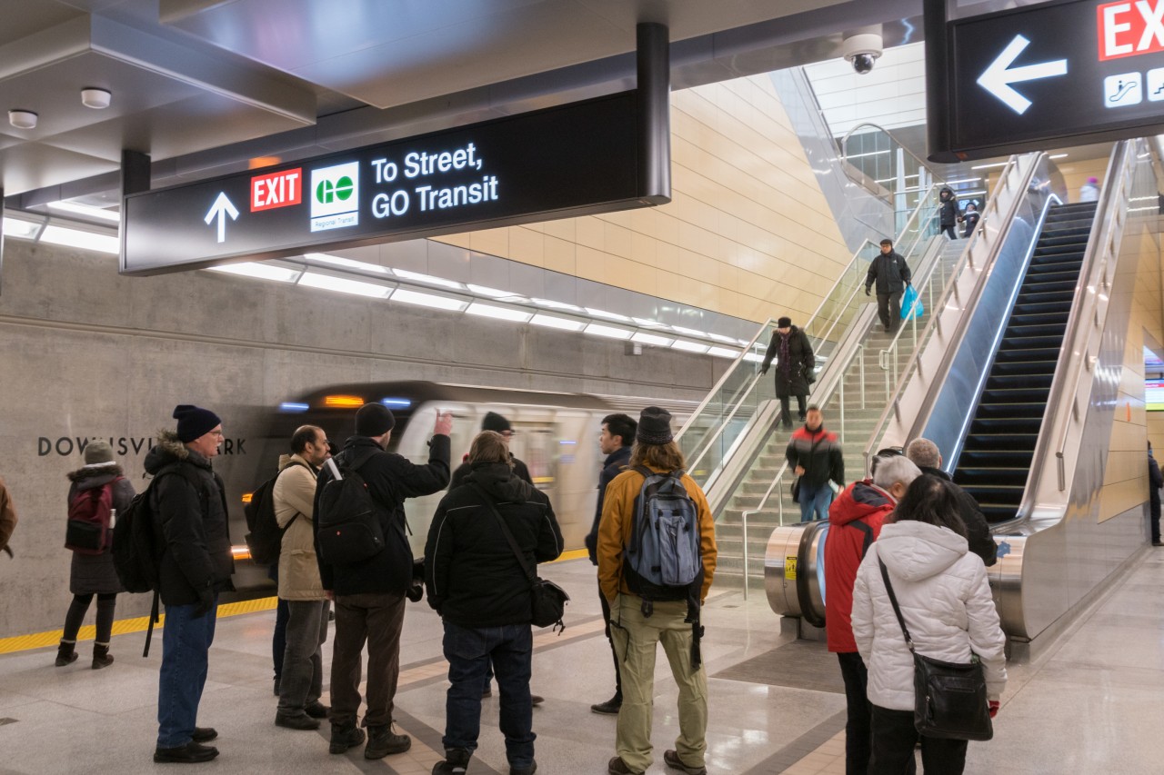 Thousands gathered for the opportunity to visit each of the six new subway stations on Line 1 as part of the Toronto-York Spadina Subway Extension. Here at Downsview Park Station, a southbound train bound for Toronto Union Station and eventually Finch enters on the southbound track, amidst a group of curious onlookers. In two weeks, the significance of this station will increase as GO trains on the Barrie Line will begin to stop here, two storeys above. Commuter train passengers will have the option to transfer to the subway for trips to areas other than the immediate downtown core around Union Station and subway passengers will be able to transfer to the train for a faster trip if their destination is near Union Station. That transfer synergy combined with development potential in its low density surroundings are sure to make this a well patronized station in the future.